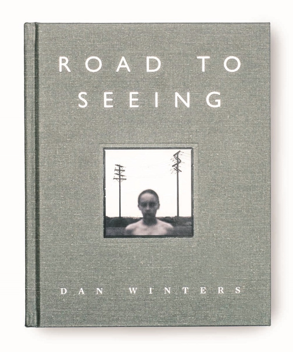 Gray book cover with white text and photo of person's head and torso in landscape